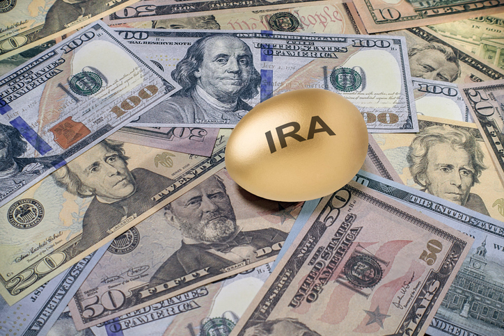 Gold egg labeled "IRA" on a pile of cash.